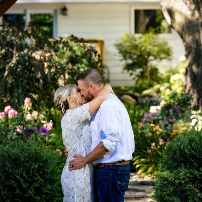 Wedding portrait of bride and groom kissing in a garden