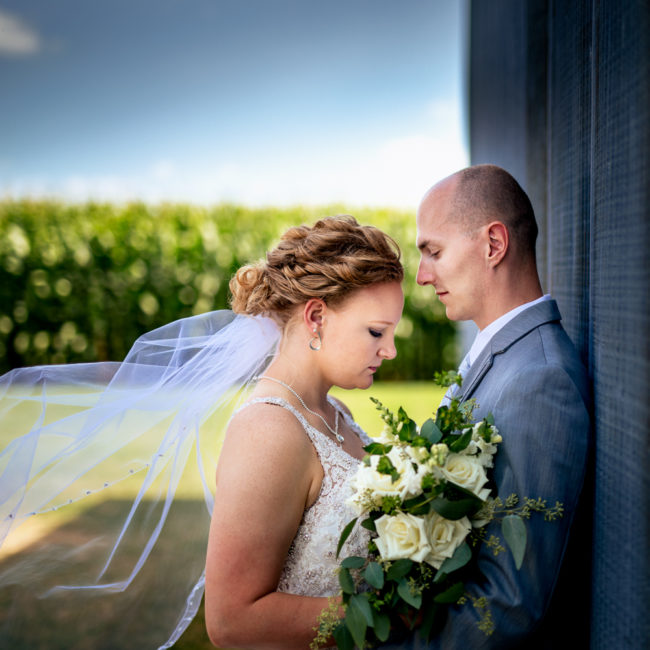 Wedding Portrait of couple leaning against a wall.